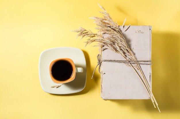 A cup of coffee, old books and dry ears of corn. Wellness, harmony, inclusiveness. Top view. Copy space