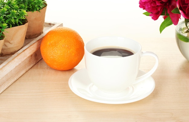 Cup of coffee orange and flowers on table in cafe