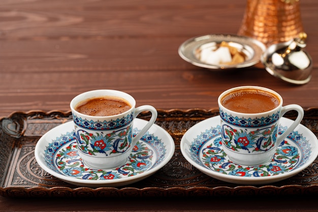 Cup of coffee in oriental style on metal tray close up