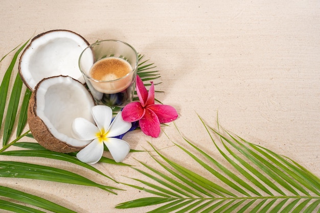 cup coffee on palm leaf at sand beach.