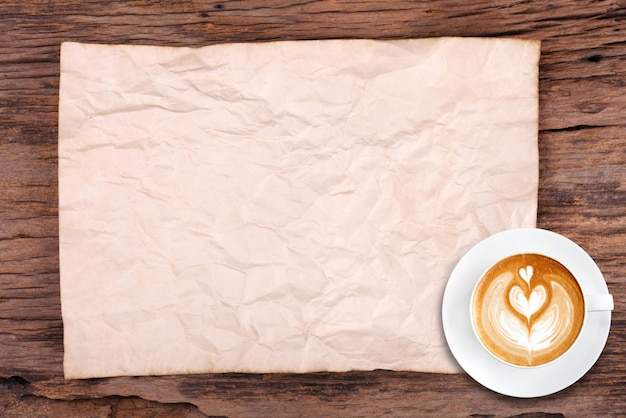 Чашка кофе и текстура бумаги на деревянном фоне
