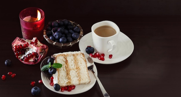 Tazza di caffè pezzo di torta alla crema con mirtilli sfondo scuro giorno di san valentino copia spazio