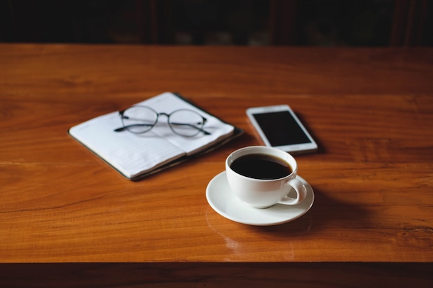 A cup of coffee placed on the desk during relax time