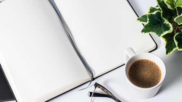 A cup of coffee and a plant on a table