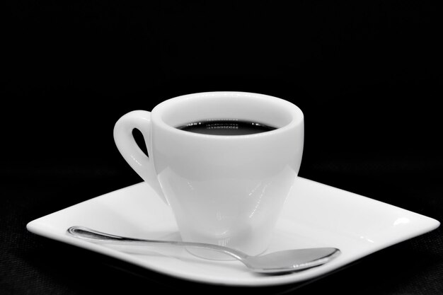 Photo cup of coffee on plate and spoon.