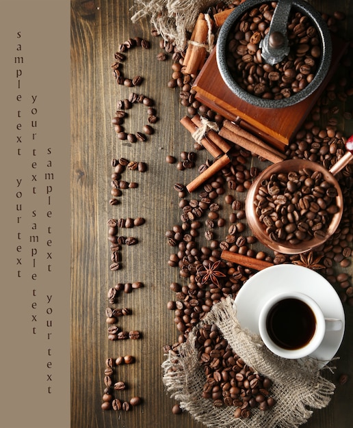 Cup of coffee, pot and grinder on wooden surface