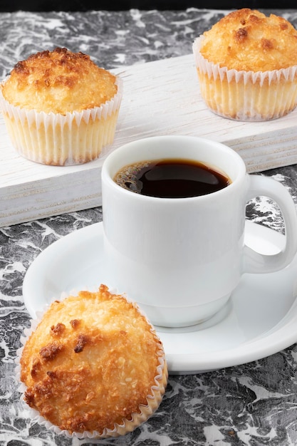 A cup of coffee served with delicious queijadinha.