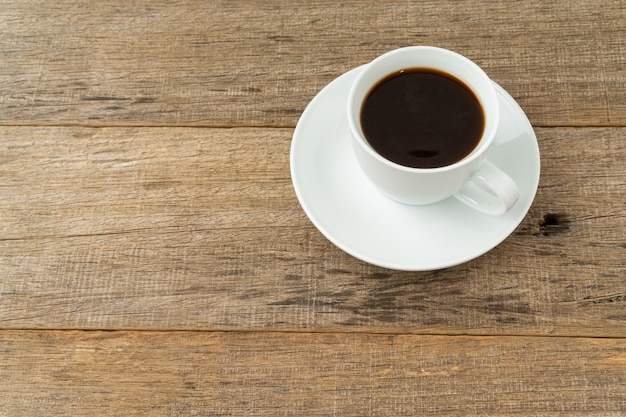 A cup of coffee on shabby wooden board.