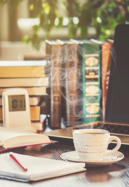 Una tazza di caffè e un buongiorno di fumo in ufficio al lavoro. messa a fuoco selettiva