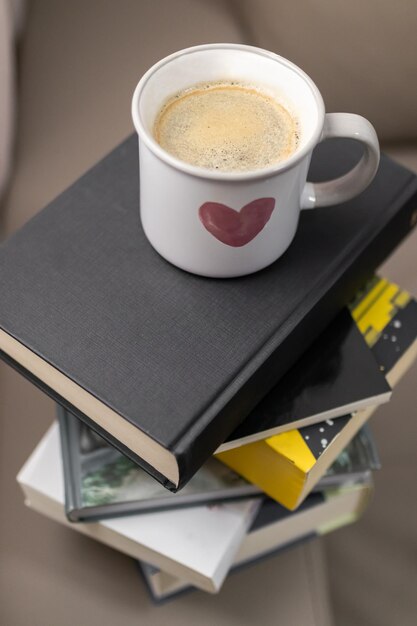 Photo a cup of coffee on some stacked books