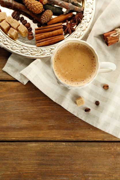 Cup of coffee and spices on metal tray on napkin