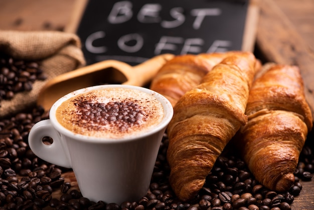 Tazza di caffè circondata da chicchi di caffè da vicino