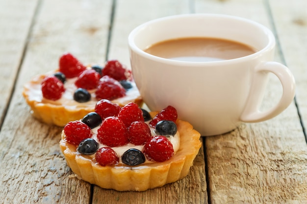 一杯のコーヒーとベリーと甘いケーキ