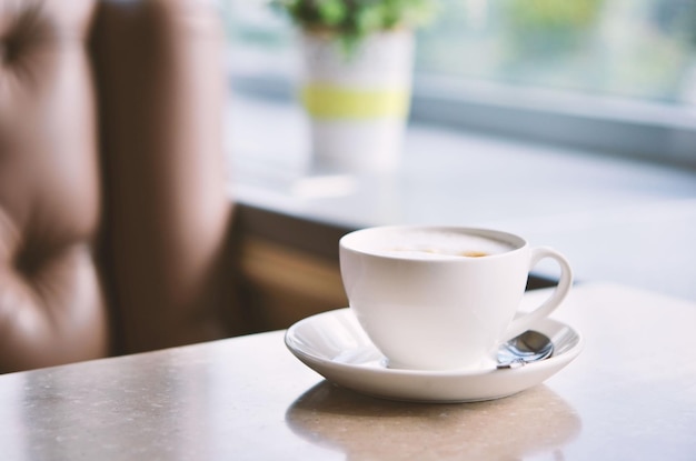 Cup of coffee on table in cafe Morning light