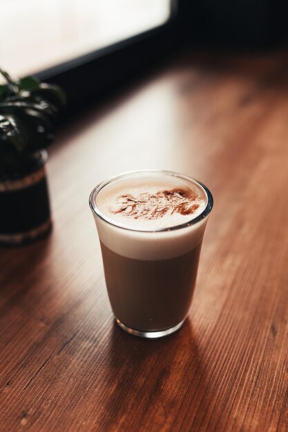 Foto coppa di caffè al tavolo in un caffè vicino alla finestra sfondo sfocato foto di alta qualità