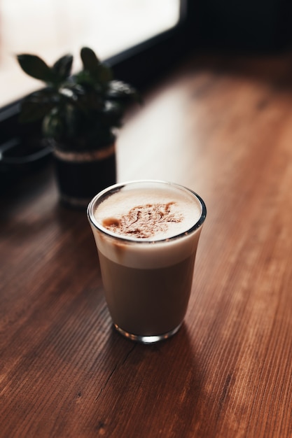 窓の近くのカフェのテーブルで一杯のコーヒー