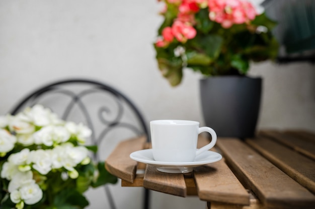 Tazza di caffè su un tavolo in un accogliente balcone con fiori. zona di comfort. giardinaggio domestico. concetto di riduzione dello stress