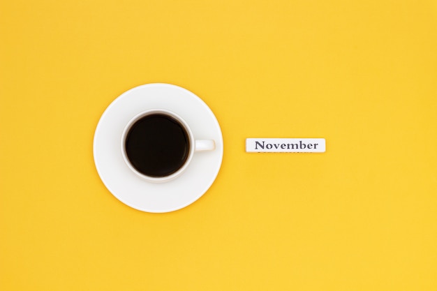 Photo cup of coffee and text november on yellow