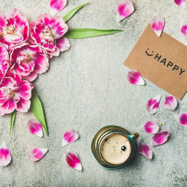 一杯のコーヒーチューリップの花と幸せな四角い作物に署名