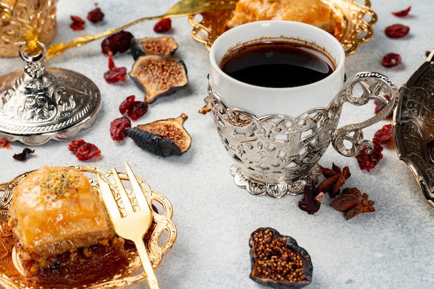 Cup of coffee and turkish pastries on dark surface close up