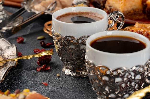 Cup of coffee and turkish pastries on dark surface