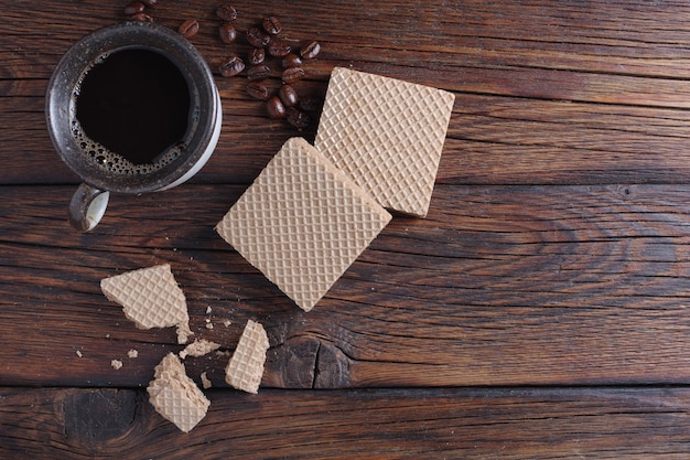 Cup of coffee and wafers on table