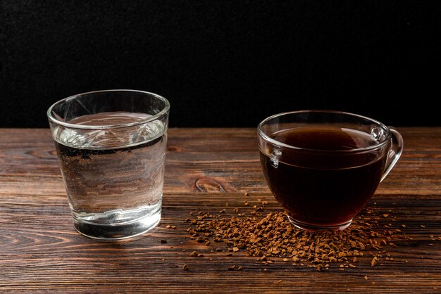 Cup of coffee and water on table