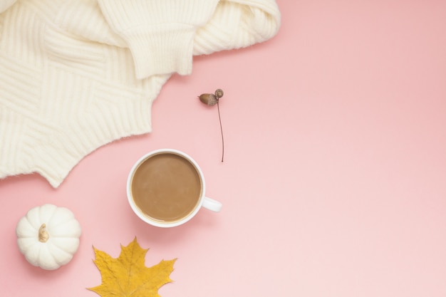 Tazza di caffè e maglione bianco sul rosa