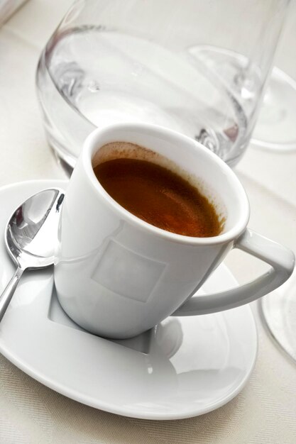 Cup of coffee on a white tablecloth