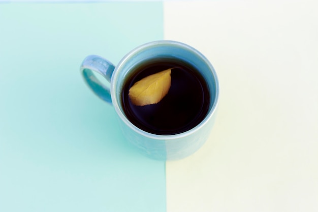 Cup of coffee with autumn leaf multicolored yellow and blue paper