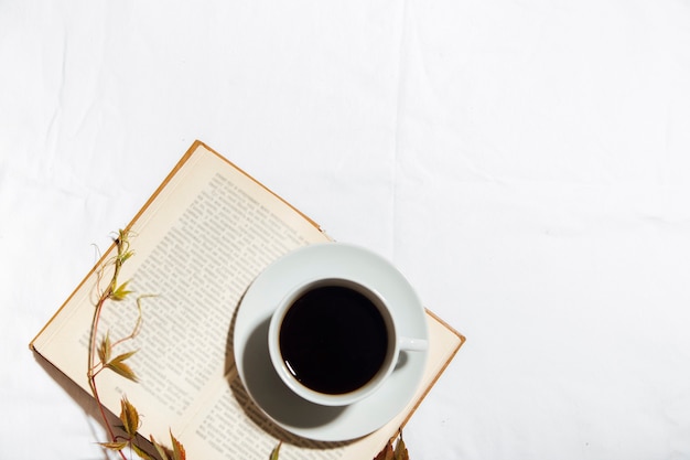 cup of of coffee with book isolated on white background top view