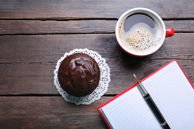 Photo cup of coffee with chocolate cake and open blank notebook on wooden background