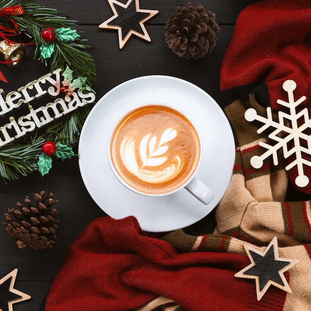 Cup of coffee with christmas decorations on black wooden table top view