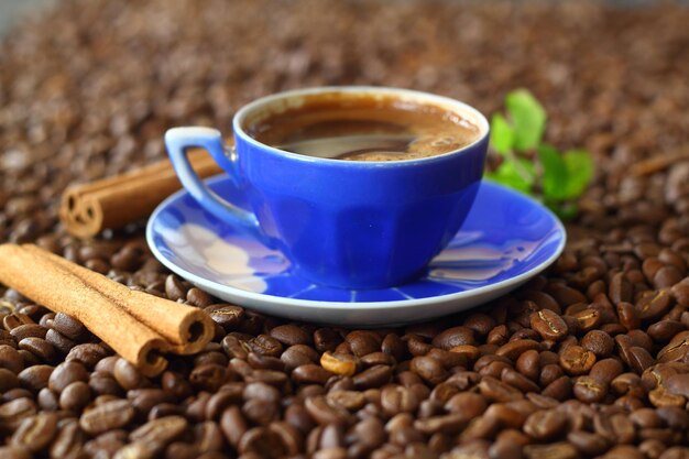 Cup of coffee with coffee beans and cinnamon sticks