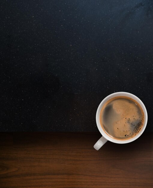 Cup of coffee with coffee beans on table