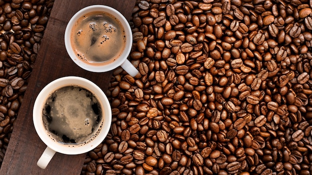 Cup of coffee with coffee beans on table