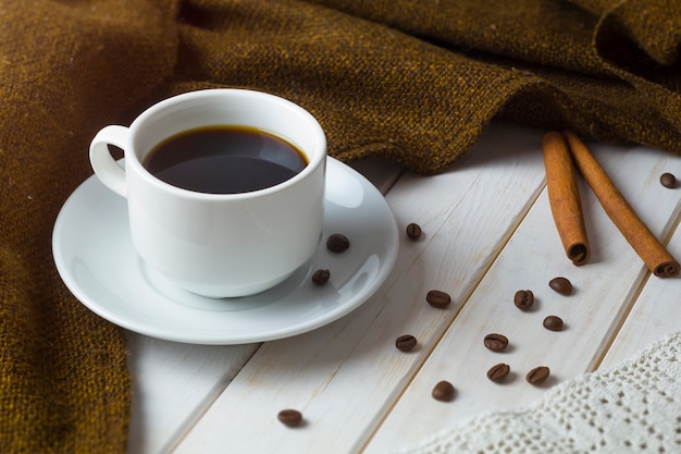 A cup of coffee with coffee beans. 