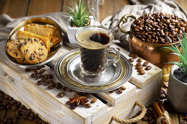 A cup of coffee with cookies and a plate of cookies