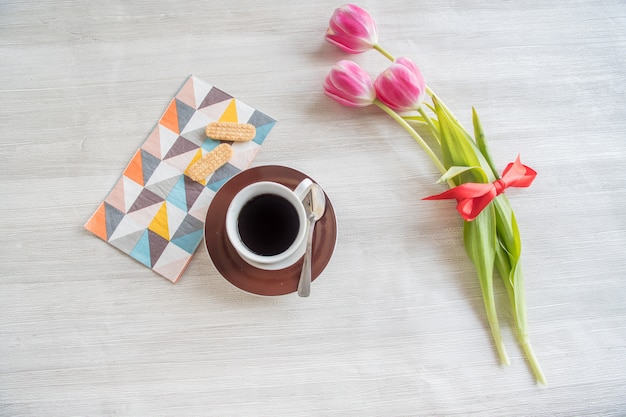 Cup of coffee with cookies and tulips, romantic breakfast