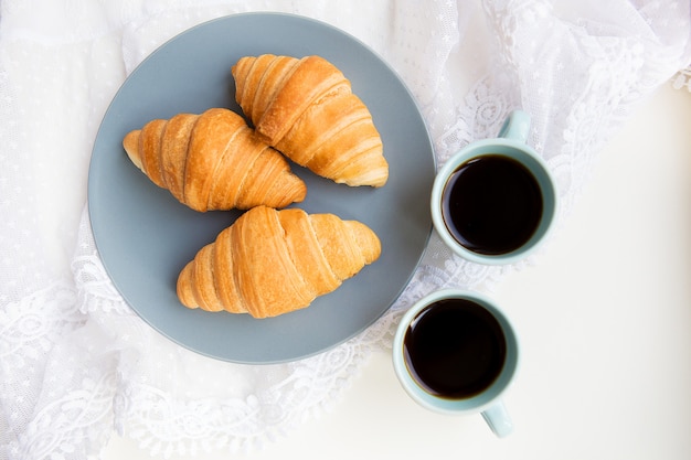 Cup of coffee with croissant