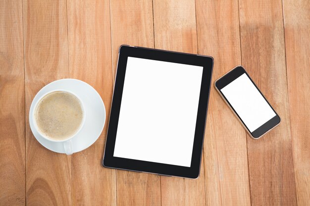 Cup of coffee with digital table and mobile phone