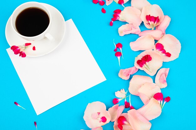 Tazza di caffè con decorazioni di fiori sul tavolo azzurro. concetto di amore e romanticismo.