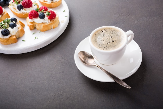 Cup of coffee with fruit sandwiches