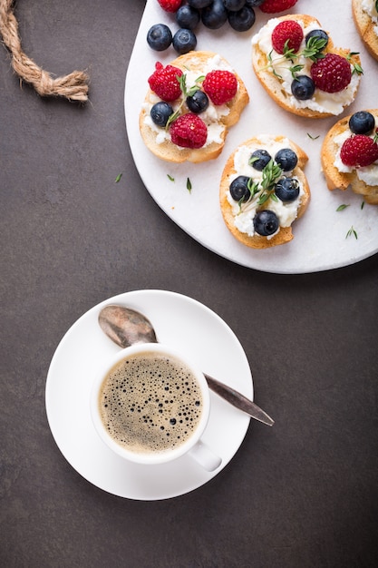 Cup of coffee with fruit sandwiches