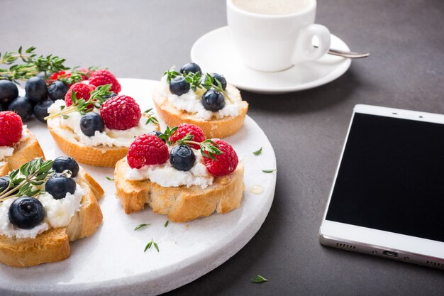 Cup of coffee with fruit sandwiches