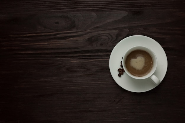 Tazza di caffè con un cuore e chicchi di caffè