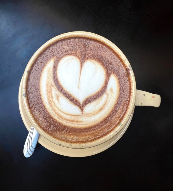 Cup of coffee with heart shape black background coffee latte art cappuccino