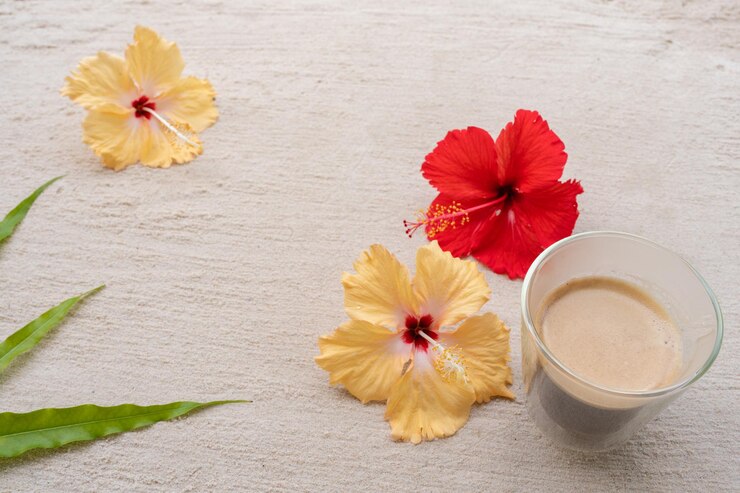 砂浜にハイビスカスを入れたコーヒーカップ。