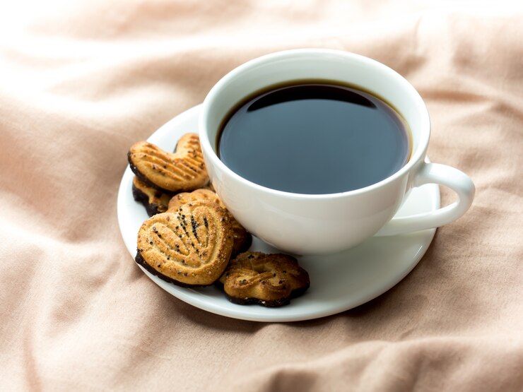 Photo ベッドの毛布の上に自家製のクッキーとコーヒー1杯
