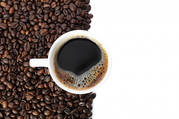 Чашка кофе с большим количеством кофейных зерен на белом фоне